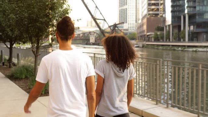 可爱的非洲裔美国夫妇一起沿着芝加哥河散步