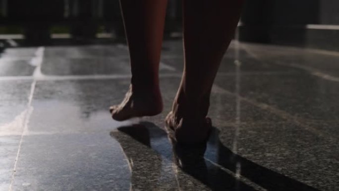 赤脚女人走在瓷砖地板上