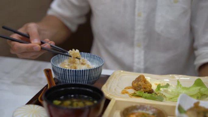 一个年轻人在日韩咖啡馆吃亚洲食物的慢动作镜头
