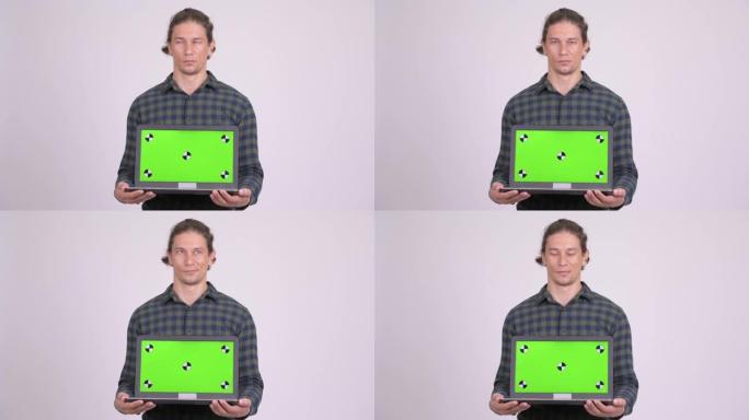 快乐英俊的潮人一边看笔记本电脑一边思考