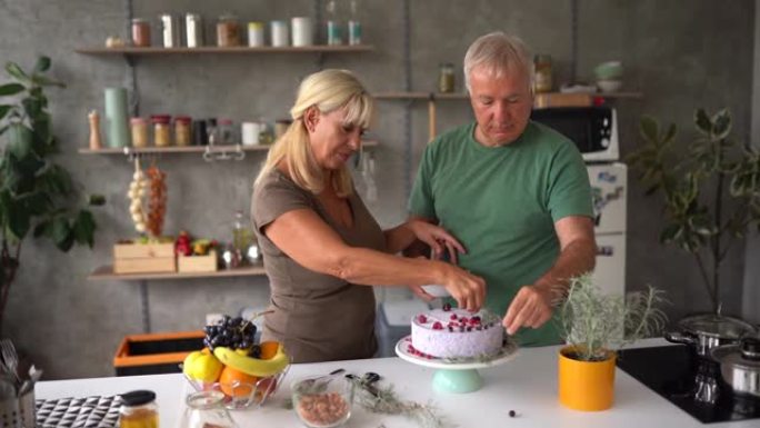 高级夫妇在家用浆果水果装饰生日蛋糕