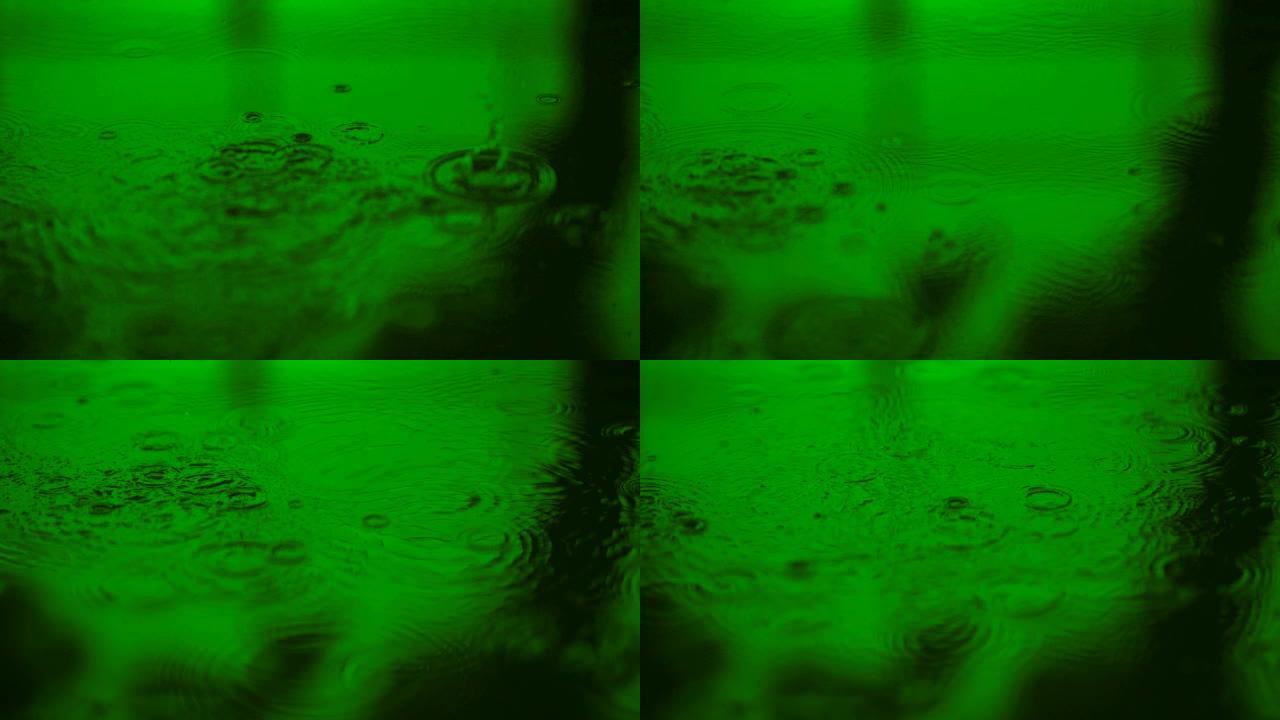 慢动作水滴落在地上的水面上，美丽的蓝色表面波抽象壁纸，地面上的圆圈图案，雨滴在潮湿的地板上落下和滴落