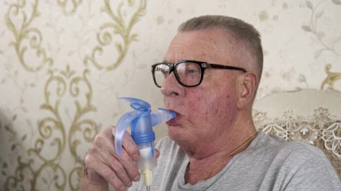 戴眼镜的老人拿着吸入器吸气