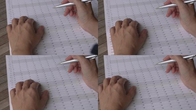 女人用手指，用笔穿过年度日历计划器。特写视图