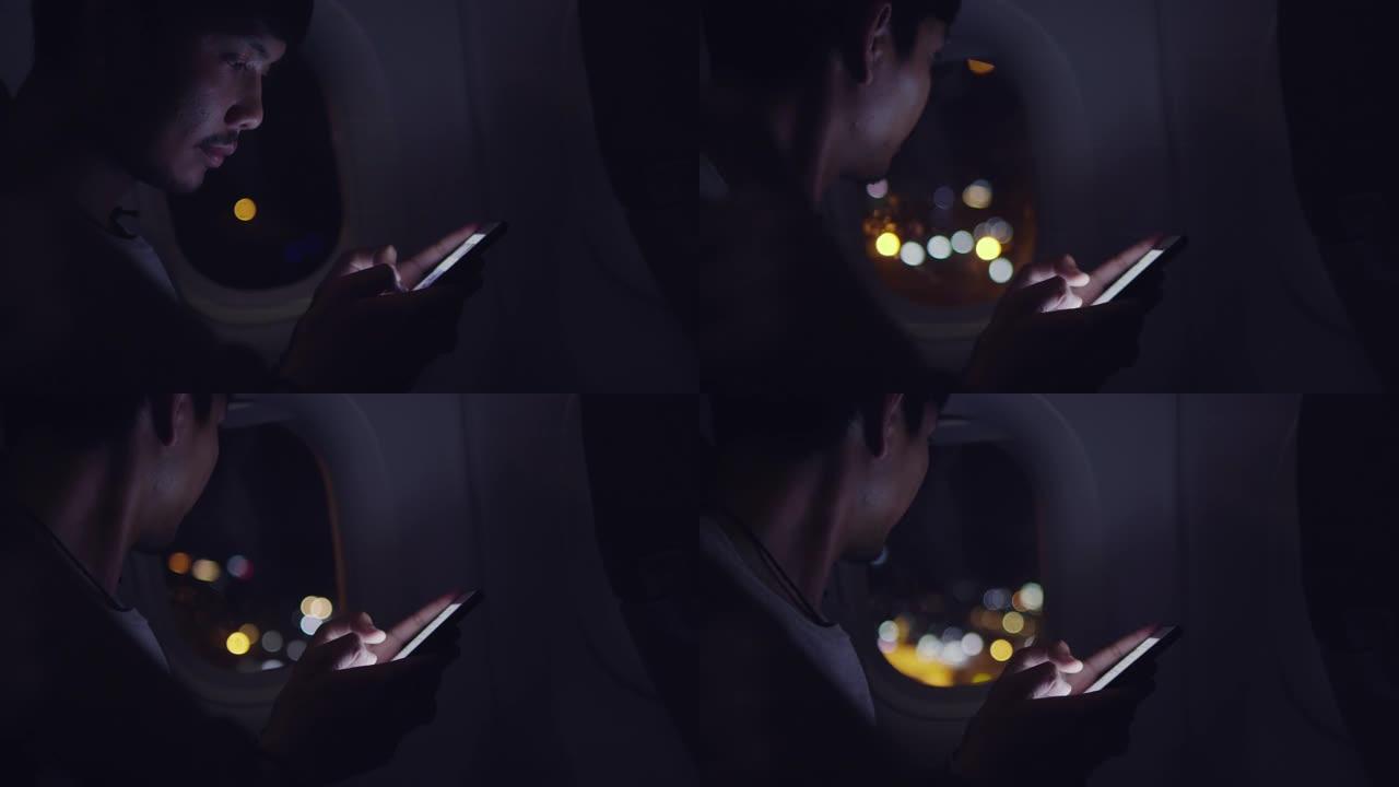 亚洲男子在飞机上使用智能手机
