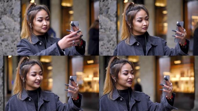 亚洲妇女在城市的智能手机上进行视频通话