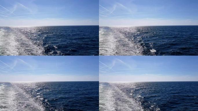 巨浪跟随船。船尾后面的波浪。从船的引擎跟踪。邮轮在蓝色的海洋上航行。船上的波浪向地平线前进。