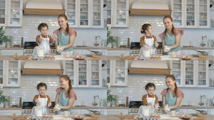 有趣的女儿和母亲在大桌子上做面团