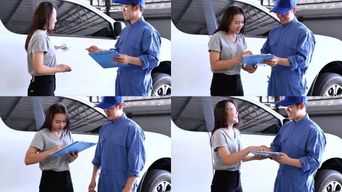 亚洲汽车技师和女性客户在汽车修理厂车库讨论修理和保养修理汽车发动机的背景。男人和女人签订合同。经营理