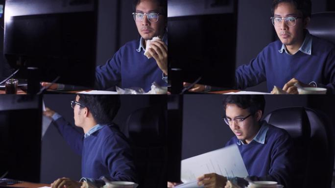 亚洲男子深夜在办公室工作，一边吃饭，没有时间吃饭的概念