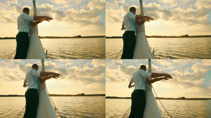 新婚夫妇站在泰坦尼 (Titani) 的帆船船头上。以美丽的日落为背景的新婚夫妇