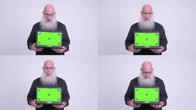 成熟的秃头大胡子男人展示笔记本电脑