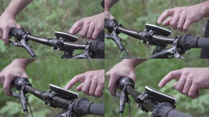 自行车手的特写镜头使用小工具进行GPS导航，建造和遵循计划的训练路线。男子触摸按钮设备活动跟踪器，记
