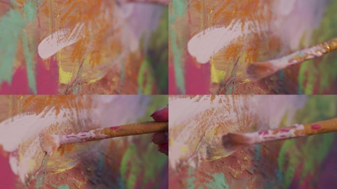 艺术家女孩用刷子的手。她在画布上绘画时动作流畅。