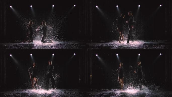 专业舞厅舞者在雨中在黑暗的工作室背景下表演jive元素。慢动作