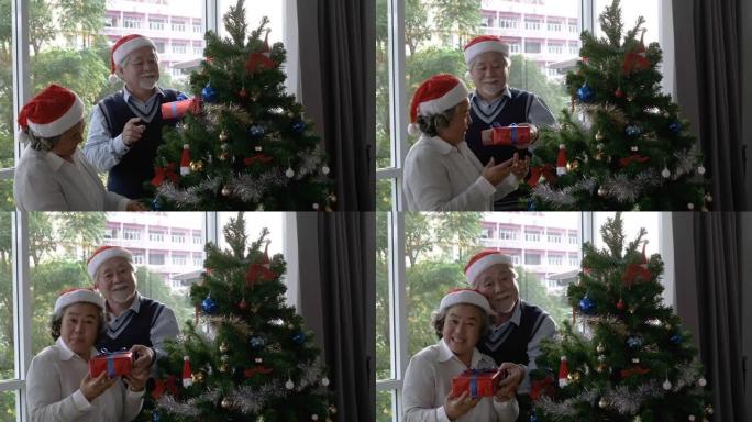 戴红帽子的老年男女赠送礼盒，并在客厅说 “新年快乐” 和 “圣诞节”