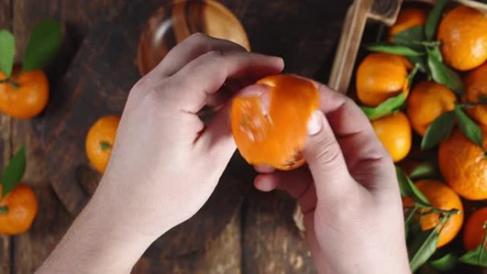 男人的手去掉橘子皮。