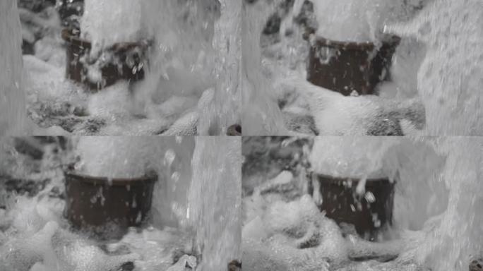 慢动作。从喷泉底座流出的水的特写视图。