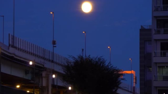 在公路桥梁上方升起月亮