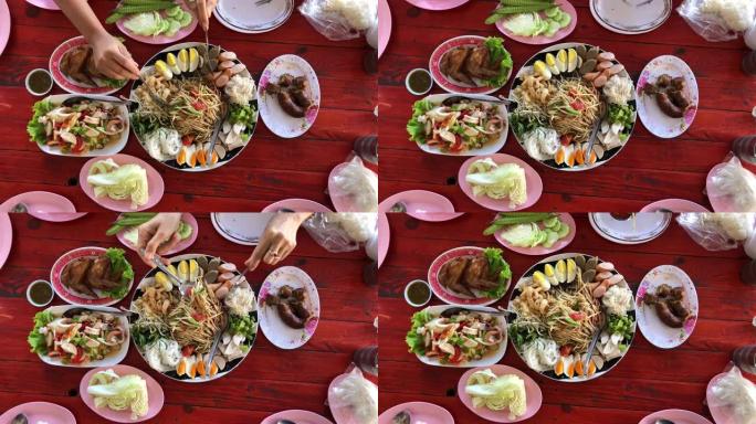 餐桌上的泰国菜: 吃东北食物 (麻辣木瓜沙拉，糯米饭，麻辣汤)。本地和传统方式。泰国菜背景。享受饮食