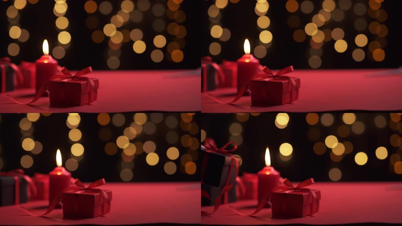 蜡烛和红色礼品盒在特殊的浪漫日子和bokeh