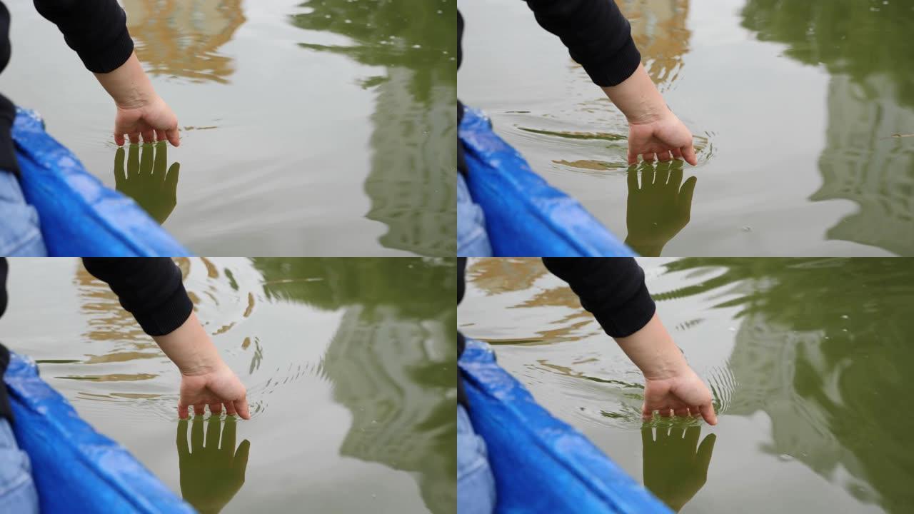 女人的手轻轻地触摸着碧绿的湖面。快乐的女孩慢慢地牵着她的手在水上。女人手触绿水的特写。女孩在湖中牵着