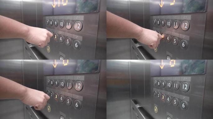 用手指指关节按下电梯的向下按钮。