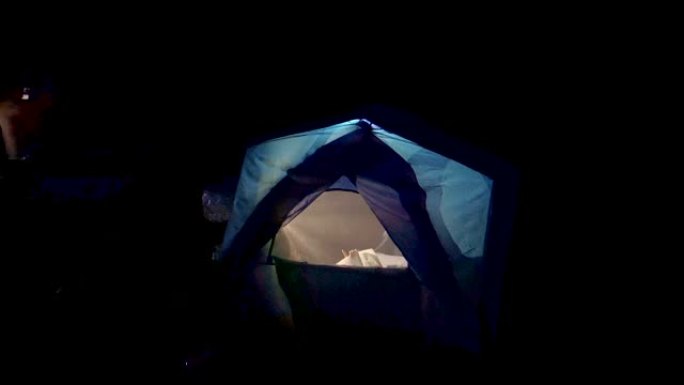 母亲晚上在帐篷里给女儿读童话故事。
