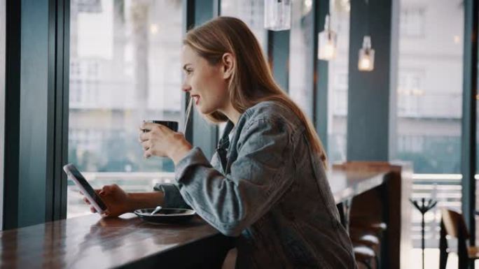 拿着手机在咖啡馆喝咖啡的女人