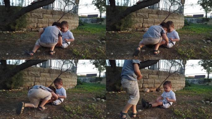可爱的4岁孩子在感到沮丧后检查并亲吻他受伤的膝盖。兄弟姐妹互相照顾