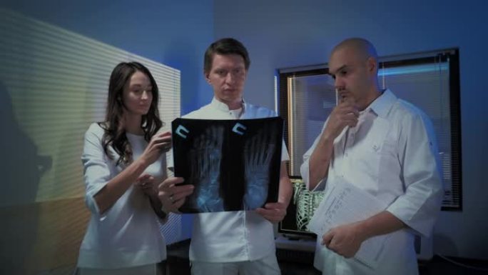 三位医生一起看一位病人的x光照片