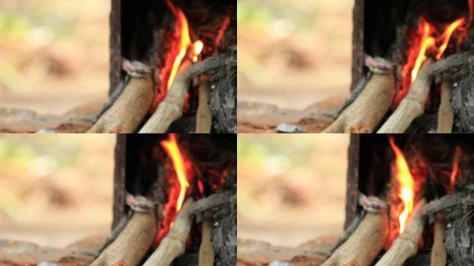 村庄里燃烧着火和柴火，背景是美丽的自然镜头。
