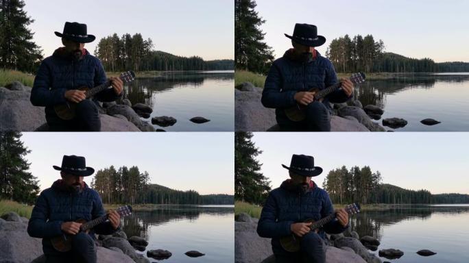 独自旅行者坐在山湖附近，在日落时用吉他演奏音乐，同时新型冠状病毒肺炎大流行。精神卫生和生活平衡。