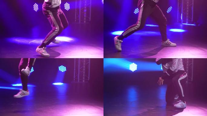 霹雳舞的动态表演，一个年轻的进步男子的嘻哈。霓虹灯下的街舞。特写。慢动作