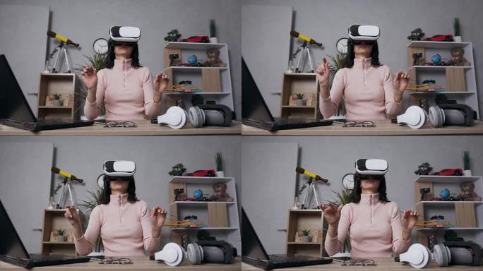 美丽集中的现代女性使用虚拟现实耳机触摸空气中的东西