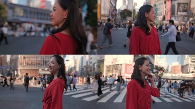 身穿红色连衣裙的年轻女子站在涩谷十字路口，望着远处