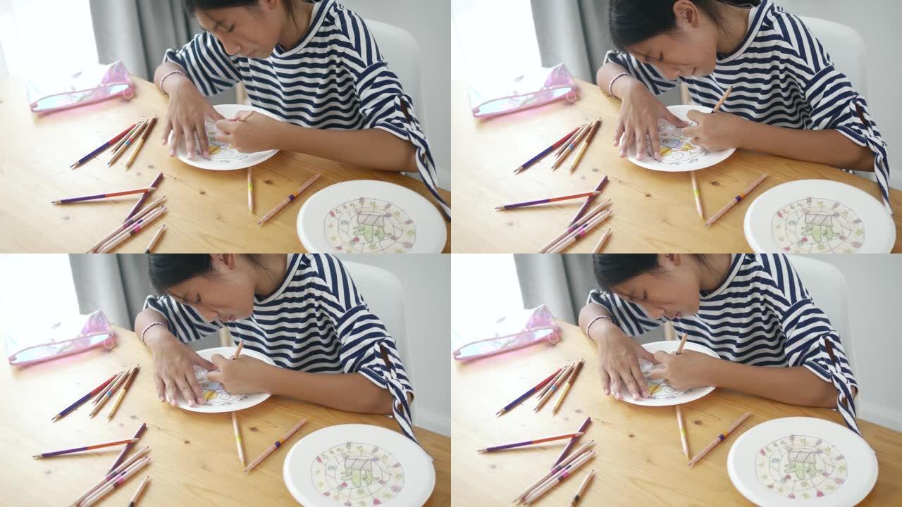 快乐的亚洲女孩在纸盘上画画，在家生活方式活动。