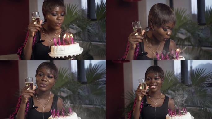 生日蛋糕上有香槟玻璃吹蜡烛的美丽非洲女孩