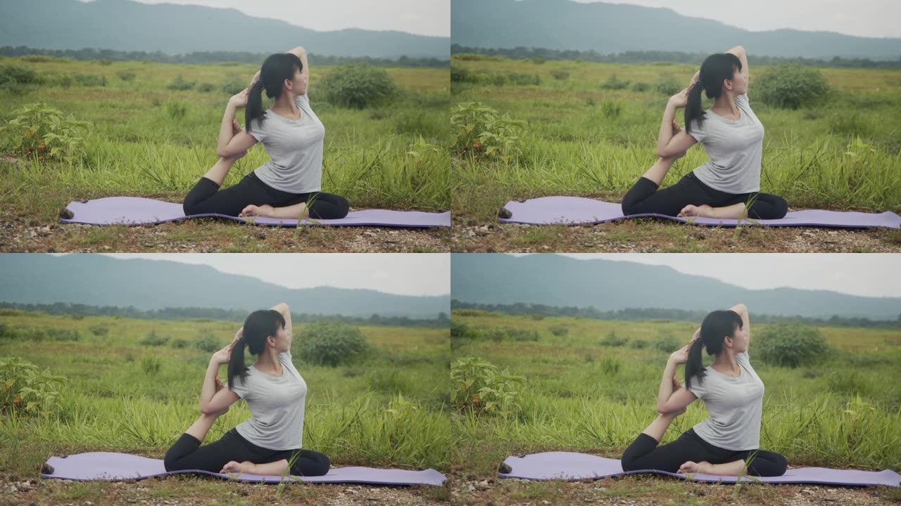 美丽的年轻亚洲女子在日出时在山景中表演精神瑜伽姿势。