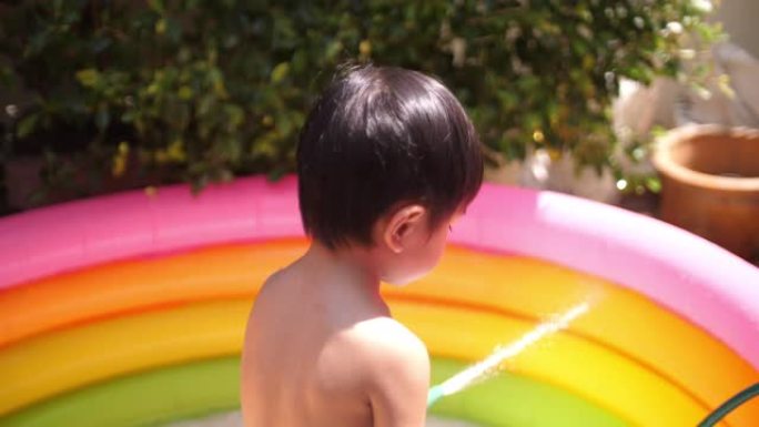 亚洲男孩在儿童游泳池里嬉水玩耍
