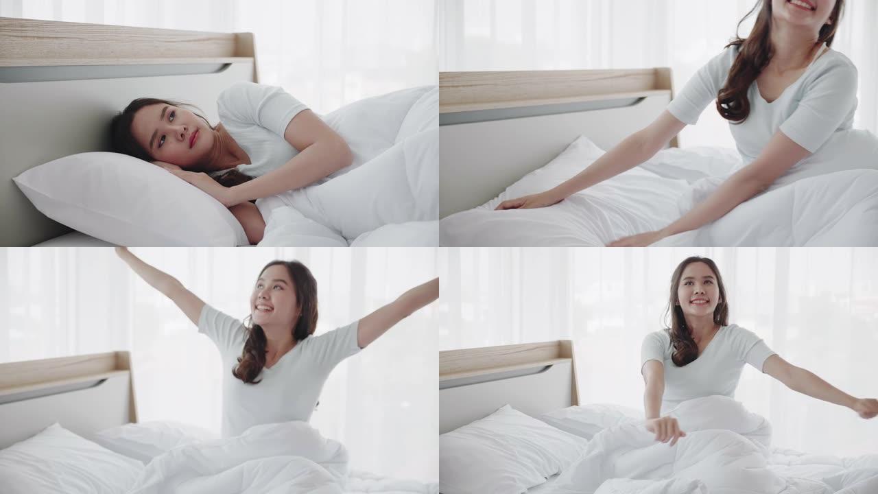 美丽的亚洲女人早上醒来感到精神焕发和快乐。充足的睡眠有助于保持你的健康。清洁卧室没有细菌和疾病。概念