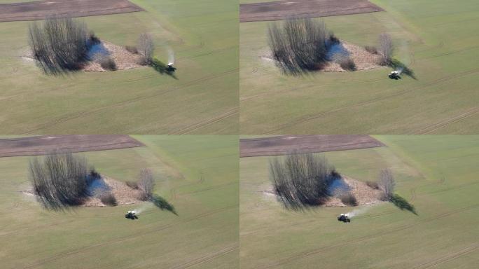 农业拖拉机在春季麦田上撒肥，空中