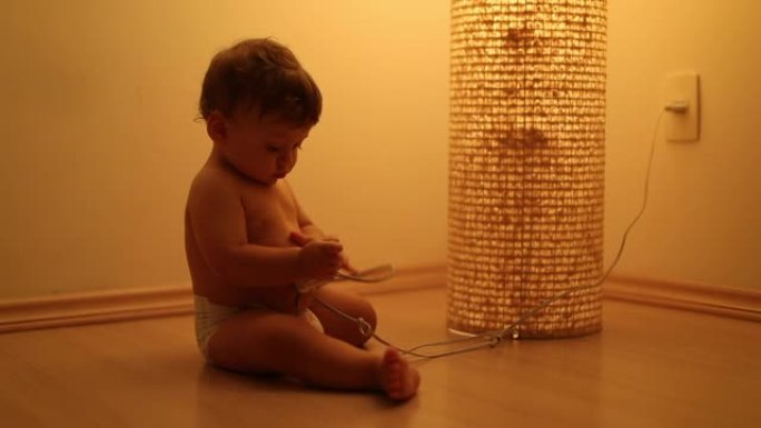 可爱的蹒跚学步的孩子玩立灯。客厅地板上的婴儿，橙色灯旁边