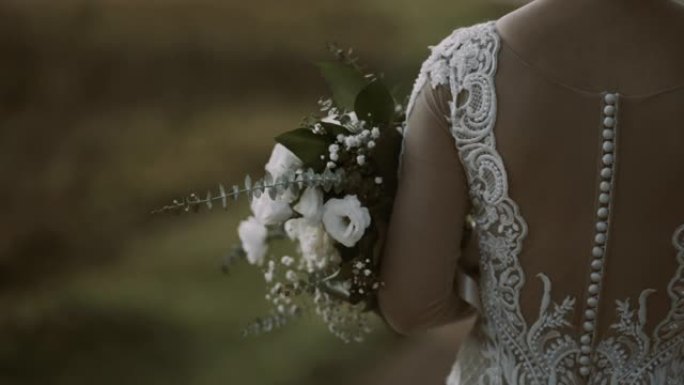 农村新娘礼服和花束的特写镜头。