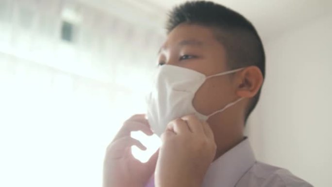 快乐的亚洲小学生早上戴着口罩，然后带着阳光上学。