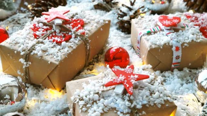 圣诞节和新年背景与礼物，丝带，球和雪上的不同装饰。用红星和心形的工艺纸包装的礼物。