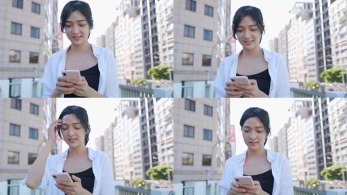 在城市街道上使用智能手机的亚洲妇女