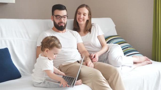 开朗迷人的夫妇坐在沙发上，笑着看着他们的孩子