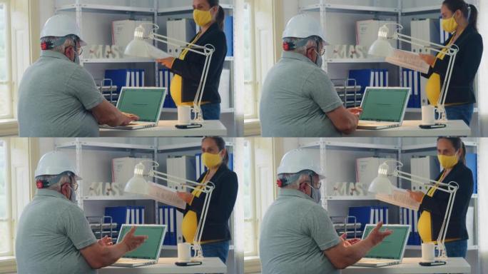 在新型冠状病毒肺炎大流行期间，商人在工作中戴着防护口罩以使曲线变平。新办公室设置中的同事，共同从事项