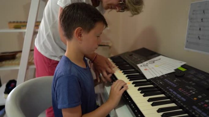 康复中心的音乐治疗师和男孩演奏合成器
